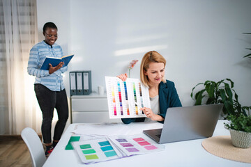 Coworkers discussing color palette during video call in office