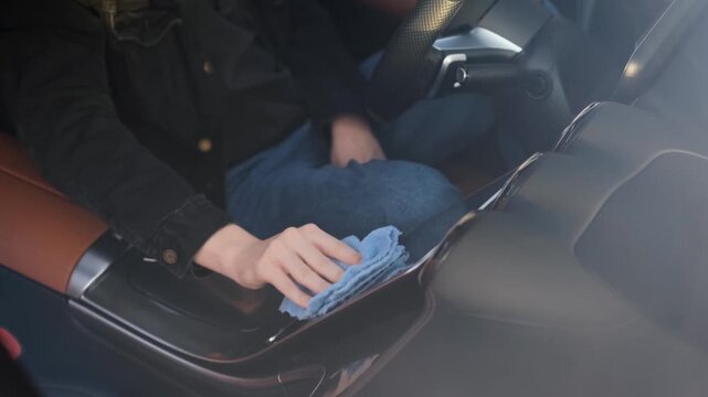 A man cleaning the digital display of a car's multimedia system, close-up