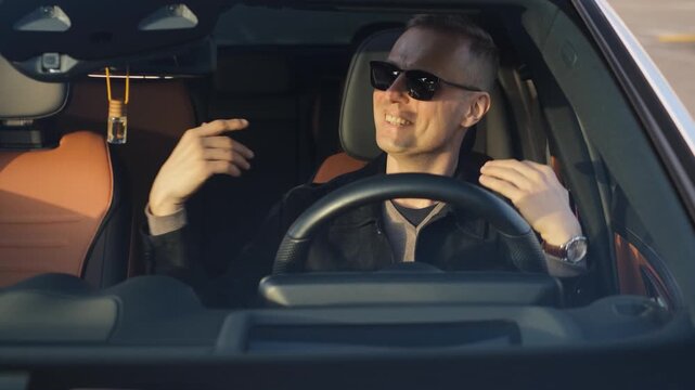 Cheerful adult man singing and moving energetically while sitting in a car