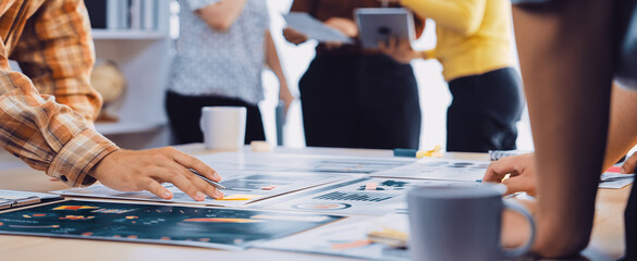 A diverse group of professionals collaborates in a modern office setting, focusing on project designs and discussions while engaged in creative brainstorming activities. SACTR