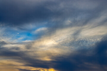 clouds in the sky at sunset with patch of blue sky