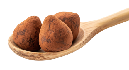 Three decadent chocolate truffles generously dusted with cocoa powder are elegantly presented on a rustic wooden spoon, isolated on a stark black background for a dramatic effect