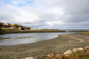A serene view of the coastal town of Sainte-Felicite, Quebec, under an overcast sky.