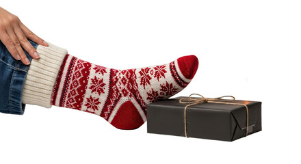 A person wearing cozy, knitted socks with a festive snowflake pattern rests their foot on a wrapped gift box, creating a warm and relaxing holiday scene against a dark background