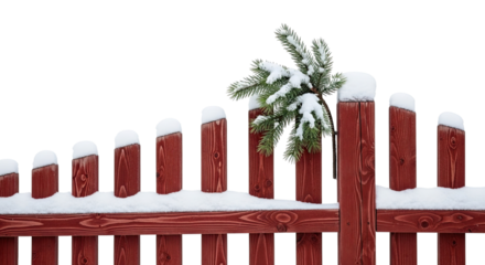 Freshly fallen snow covers a traditional red wooden fence and a small fir tree branch, creating a classic and minimalist winter scene isolated on a black background