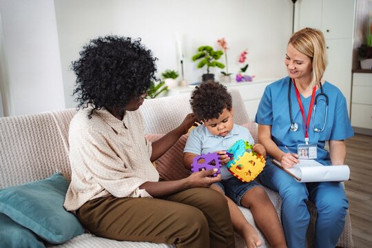 Nurse measuring child temperature at home