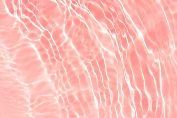 Pink water bubbles on the surface ripples. Defocus blurred transparent pink colored clear calm water surface texture with splash and bubbles. Water waves with shining pattern texture background