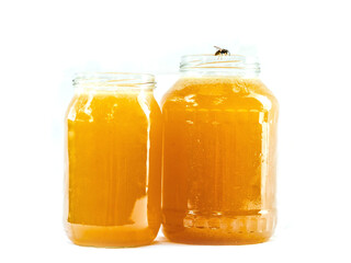 Glass jar of golden bee honey is on a white background. Fine organic product concept. Agriculture and food industry.