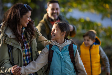 Family enjoys hiking together in a serene forest in autumn