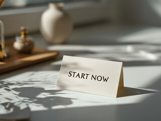 Inspirational message on a card urging immediate action in a bright, serene workspace setting