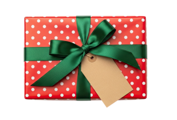 A festive gift box wrapped in red and white polka dot paper with a green satin ribbon and a blank tag, seen from a top-down perspective and isolated on a black background