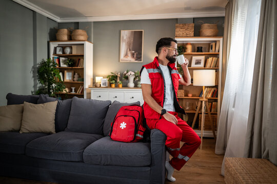 Paramedic man relaxing at home drinking coffee