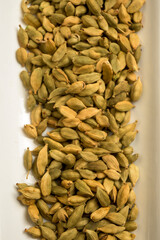 Vertical Overhead View of Cardamom Pods on White Surface