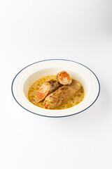 Stuffed meat rolls with carrot filling in savory gravy on a white background