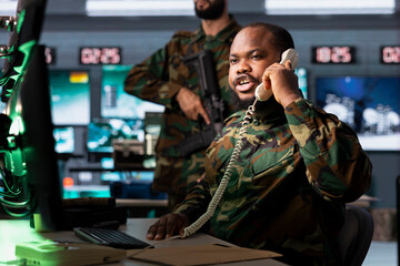 Military officer reporting battlefield information to army decision makers during telephone call. Dispatcher phoning generals to give enemy coordinates, tracking air traffic movement