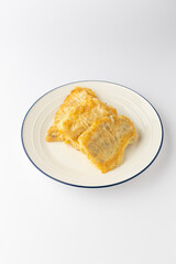 Crispy battered fish fillets on a plate, isolated on white background