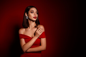 Elegant red dress worn by a stylish woman with bold makeup and statement earrings dark red backdrop for beauty fashion