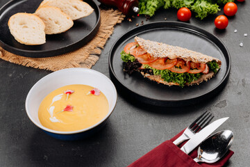 Healthy flatbread sandwich with lettuce and tomato, creamy soup, restaurant setting