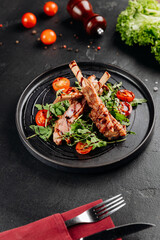 Grilled ribs on arugula with cherry tomatoes and balsamic glaze, restaurant plating