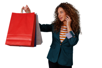 Woman holding colorful shopping bags and talking on mobile phone during retail therapy or discount sales event
