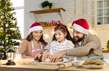 Christmas happy family baking cookies in cozy kitchen. Parents help child girl knead dough, cooking together in festive home. Winter holidays celebration, joy and togetherness concept.
