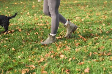 Woman wearing wellies on dog walk in autumn field