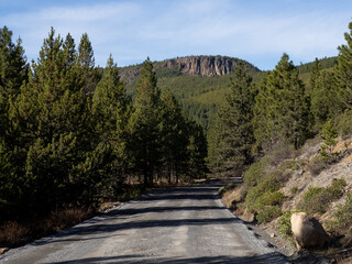 A rugged hill in the background on a backroad in Central Oregon on a nice day.