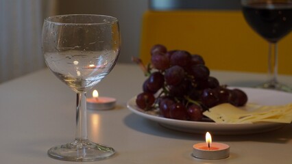 Romantic couple enjoying dinner at home, concept love, relationship and romantic, happy couple celebrating and making cheers with glasses of red wine. girl eats grapes and cheese, Valentine's Day