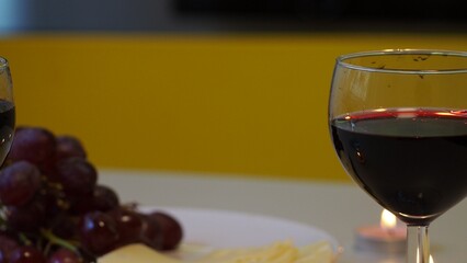Romantic couple enjoying dinner at home, concept love, relationship and romantic, happy couple celebrating and making cheers with glasses of red wine. girl eats grapes and cheese, Valentine's Day