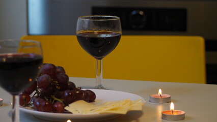 Romantic couple enjoying dinner at home, concept love, relationship and romantic, happy couple celebrating and making cheers with glasses of red wine. girl eats grapes and cheese, Valentine's Day