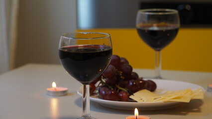 Romantic couple enjoying dinner at home, concept love, relationship and romantic, happy couple celebrating and making cheers with glasses of red wine. girl eats grapes and cheese, Valentine's Day