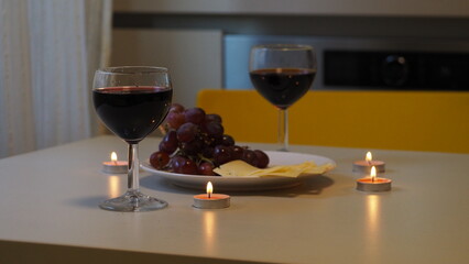Romantic couple enjoying dinner at home, concept love, relationship and romantic, happy couple celebrating and making cheers with glasses of red wine. girl eats grapes and cheese, Valentine's Day