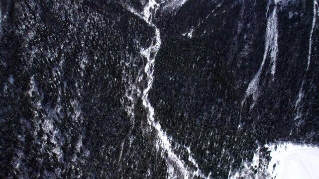 Drone view of snow covered mountains and forests in Bipeng Valley in Sichuan, China in sunny winter day, high angle view of beautiful winter landscape. 4k real time footage, travel concept