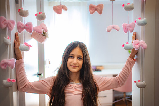 Girl smiling in a doorway with pink bow decorations