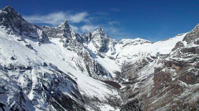 Drone view of snow covered mountains and forests in Bipeng Valley in Sichuan, China in sunny winter day, high angle view of beautiful winter landscape. 4k real time footage, travel concept