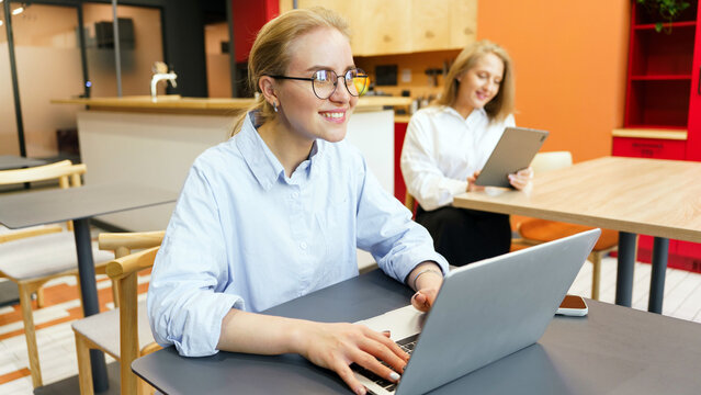 People working on laptops in a modern cafe setting