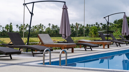 Sun bed chair on the edge of a hotel or resort swimming pool