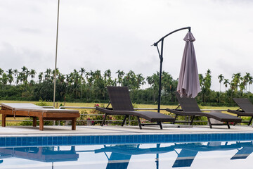Sun bed chair on the edge of a hotel or resort swimming pool