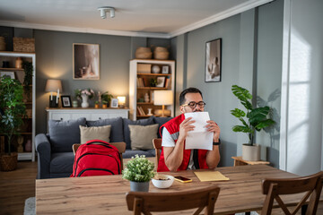 Man in paramedic uniform at home feeling relief after reading good news letter
