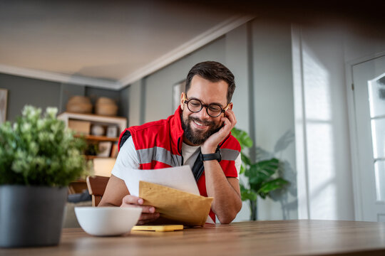Male paramedic reading a letter while relaxing off-duty at home - Powered by Adobe