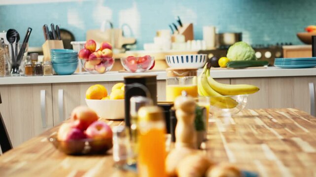 Empty modern kitchen interior in a contemporary apartment. Bright space includes a clean table, stylish kitchenware, fresh fruits and condiments on the counter. Healthy cooking in cozy home.