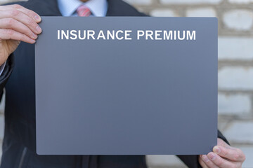 Business person holding gray empty banner for YOUR textsees the inscription: INSURANCE PREMIUM. Insurance premium business service concept. Car, house, life, health insured.