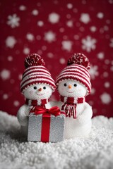 Cute snowmen couple celebrating winter holidays, sharing a silver gift box on red background with snowflakes