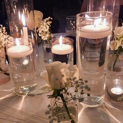 A white rose and candles in a wedding table setting.