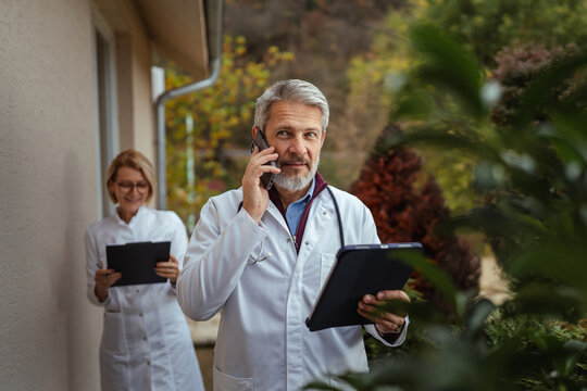 Healthcare team communicating outside with tablet and smart phone