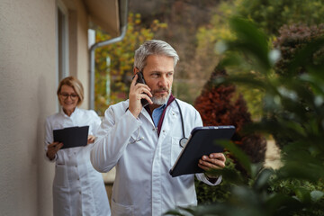 Healthcare team communicating outside with tablet and smart phone
