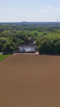 moves empty fields green trees seneffe town visible distant windmills add rural charm landscape natural to right forward aerial drone belgium 