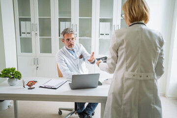 Senior doctors discussing medical results in modern healthcare office