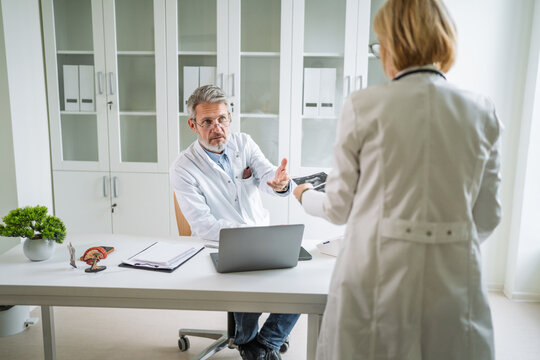Senior doctors discussing medical results in modern healthcare office