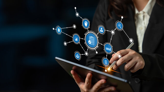 A business analyst interacts with a digital tablet showcasing a data visualization interface, illustrating various information icons for technology and analysis. Tessel - Powered by Adobe